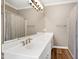 Bright bathroom featuring a white vanity, gold fixtures, and a large mirror reflecting the shower at 8724 Ten Ten Rd, Raleigh, NC 27603