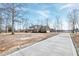 Beautiful brick home with well-maintained landscaping, long driveway, and a blue sky backdrop at 8724 Ten Ten Rd, Raleigh, NC 27603