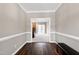 Hallway leads to carpeted living room featuring a brick fireplace and large windows at 8724 Ten Ten Rd, Raleigh, NC 27603