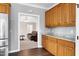 Kitchen with wooden cabinets, stainless steel fridge, and view into the living room at 8724 Ten Ten Rd, Raleigh, NC 27603