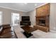 Spacious living room with a brick fireplace, carpeted flooring, and large windows at 8724 Ten Ten Rd, Raleigh, NC 27603
