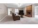 Comfortable living room featuring a brick fireplace, neutral walls, and carpeted floors at 8724 Ten Ten Rd, Raleigh, NC 27603