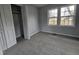 Neutral bedroom featuring plush carpeting, double windows providing natural light, and a spacious closet at 912 Hillsboro St, Oxford, NC 27565