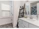 Well-lit bathroom with a white vanity, decorative ladder shelf, and wood-look flooring at 94 Paperwhite Pl, Clayton, NC 27527