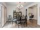 Elegant dining room with a chandelier, wood table with seating for six, and a built-in cabinet at 94 Paperwhite Pl, Clayton, NC 27527