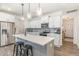 Bright kitchen with white cabinets, stainless appliances, an island with stools, and hardwood floors at 94 Paperwhite Pl, Clayton, NC 27527