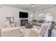 Comfortable living room featuring neutral-toned sofas, a fireplace, and a large window with natural light at 94 Paperwhite Pl, Clayton, NC 27527