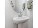 Clean powder room featuring a pedestal sink, a mirror, and decorative towels at 94 Paperwhite Pl, Clayton, NC 27527