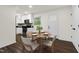 Light-filled dining area features wood-look floors and leads to a pristine kitchen with white appliances at 1006 Linwood Ave, Durham, NC 27701