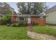 Quaint brick home featuring lush greenery and a well-maintained yard at 1006 Linwood Ave, Durham, NC 27701