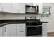 Modern kitchen with white cabinets, stainless steel appliances, and black countertops, combining style and practicality at 1006 Linwood Ave, Durham, NC 27701
