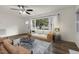Bright living room boasts large windows, a ceiling fan, and neutral tones with wood-look floors at 1006 Linwood Ave, Durham, NC 27701