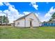 Exterior rear view of white home with green lawn under a cloudy sky at 1021 E Edgerton St, Dunn, NC 28334