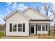 Charming single-story home featuring white siding, black shutters, and a welcoming front porch at 1021 E Edgerton St, Dunn, NC 28334
