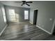 Spacious bedroom has light gray walls, new vinyl flooring, ceiling fan, and large windows at 104 Ginger Cir, Selma, NC 27576