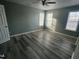 Bright bedroom features new gray vinyl floors, ceiling fan, and plenty of natural light from the windows at 104 Ginger Cir, Selma, NC 27576