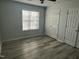 Bedroom features light gray vinyl flooring, ceiling fan, large windows, and closet at 104 Ginger Cir, Selma, NC 27576