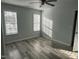 Bright bedroom has gray walls, new vinyl flooring, ceiling fan, and multiple windows at 104 Ginger Cir, Selma, NC 27576