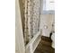 This bathroom has a floral shower curtain, vintage tiled walls, and a toilet at 1111 Spring Valley Lake Rd, Henderson, NC 27537
