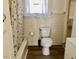 This bathroom has vintage tiled walls, a floral shower curtain and a toilet at 1111 Spring Valley Lake Rd, Henderson, NC 27537