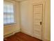 This bedroom features hardwood floors, a window with blinds, and a closet door at 1111 Spring Valley Lake Rd, Henderson, NC 27537