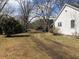 View from the side yard towards the driveway, showing a home and surrounding trees at 1111 Spring Valley Lake Rd, Henderson, NC 27537