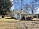 White one story home with a car port and a vintage red sports car at 1111 Spring Valley Lake Rd, Henderson, NC 27537