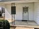 Charming front porch with a decorative door and adjacent window at 1111 Spring Valley Lake Rd, Henderson, NC 27537