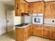 Kitchen featuring oak cabinets, white appliances, and tile flooring at 1111 Spring Valley Lake Rd, Henderson, NC 27537