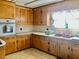 Kitchen featuring oak cabinets, white appliances, and tile flooring at 1111 Spring Valley Lake Rd, Henderson, NC 27537