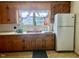 Kitchen featuring oak cabinets, white appliances, and tile flooring at 1111 Spring Valley Lake Rd, Henderson, NC 27537