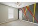 Bedroom with a fan, window with blinds, painted accent wall, and neutral colored carpet at 1112 Jewel Creek Dr, Cary, NC 27519