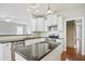 Modern kitchen with granite countertops, stainless steel appliances, and an island with a breakfast bar at 1112 Jewel Creek Dr, Cary, NC 27519