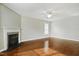 Bright living room featuring a fireplace, hardwood floors, ceiling fan, and natural light at 1112 Jewel Creek Dr, Cary, NC 27519