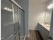 Bathroom featuring double sinks, vinyl floors, granite countertops and a large glass shower at 11186 Salers Loop, Middlesex, NC 27557