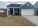 Charming single-story home with blue siding, a white garage door, and a covered entryway at 11186 Salers Loop, Middlesex, NC 27557