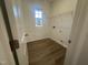 Laundry room featuring vinyl floors, a window, washer/dryer hookups and wire rack shelving at 11186 Salers Loop, Middlesex, NC 27557
