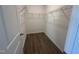 Walk-in closet featuring wood-look floors, neutral walls, and wire rack shelving at 11186 Salers Loop, Middlesex, NC 27557