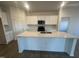 Modern kitchen featuring an island, stainless steel appliances, and bright white cabinets at 11844 Ayshire Dr, Middlesex, NC 27557