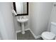 Powder room with pedestal sink, decorative mirror, and toilet at 122 Banyon Tree Ln, Cary, NC 27513