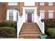 Stairway leading to a red front door with white trim and well manicured bushes at 122 Banyon Tree Ln, Cary, NC 27513