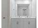 Bathroom featuring a dual vanity, large mirror, and white cabinets at 140 Baker Farm Dr, Youngsville, NC 27596