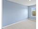 A bright bedroom featuring a light blue wall and a window at 140 Baker Farm Dr, Youngsville, NC 27596
