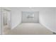 Carpeted bedroom with a large window for natural lighting and a doorway that leads to an en suite bathroom at 140 Baker Farm Dr, Youngsville, NC 27596