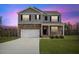 Charming two-story home featuring stone accents, gray siding, and a well-maintained lawn at 140 Baker Farm Dr, Youngsville, NC 27596