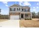Charming two-story home featuring stone accents, gray siding, and a well-maintained lawn at 140 Baker Farm Dr, Youngsville, NC 27596