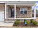 Inviting front porch with stone accents and an ADT security sign in the manicured garden at 140 Baker Farm Dr, Youngsville, NC 27596