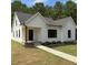 Stylish modern farmhouse with a walkway, manicured lawn, black trim windows, and eye-catching curb appeal at 148 Mohawk Dr, Louisburg, NC 27549