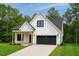 New home with a modern farmhouse design, black garage door, a manicured lawn, and black trim windows at 148 Mohawk Dr, Louisburg, NC 27549