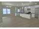 Open concept kitchen with white cabinets, large island, stainless appliances, and wood floors at 148 Mohawk Dr, Louisburg, NC 27549